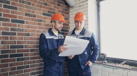 Two workers at building site with blueprints Stock Footage 68424239