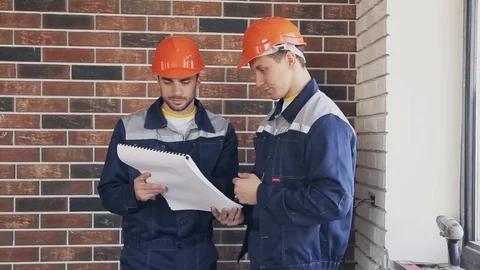 Two workers at building site with blueprints Stock Footage 70421969