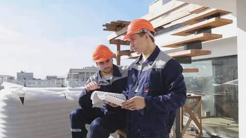 Two workers at building site with blueprints Stock Footage 71367161