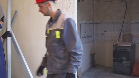 Two workers carry building materials at a construction site Video stock 99751149