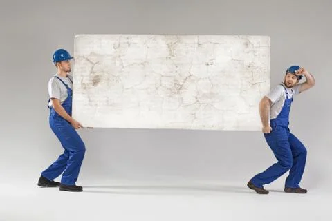Two workers carrying crashed banner 스톡 사진