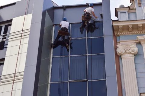 Two Workers cleaning windows service on high rise building Stock Photos