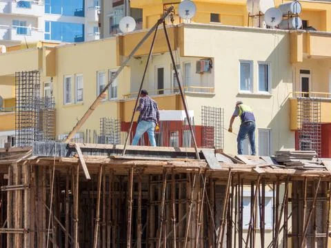 Two workers on the construction of a residential multi-storey building Stock Photos