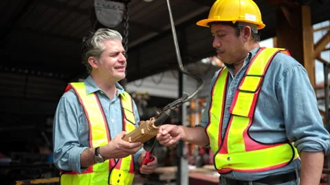 Two workers on a construction site are demonstrating the operation of a crane Video stock 291852566