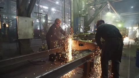 Two Workers cuts and grinds Through the Heavy Part of the metal Train wheel Stock Footage 157677093