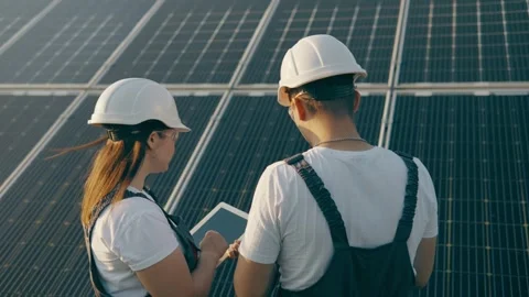Two workers discussing the installation and effectiveness of solar panels Stock Footage 256835020