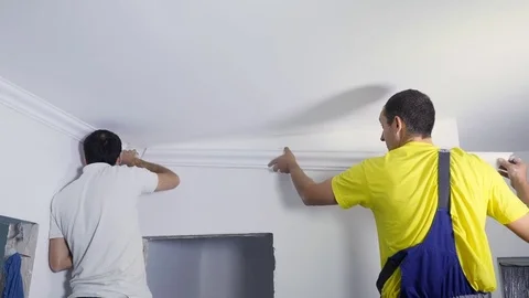 Two Workers fixes the plinth to the ceiling Stock Footage 82388068