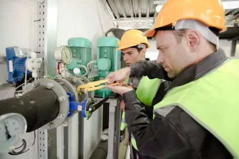 Two workers fixing pipes Stock Photos
