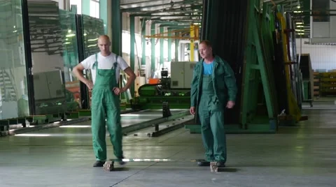 Two Workers in Green Uniform, Boots, Are Standing at the Sheet of Glass, Sheet Stock Footage 53011377