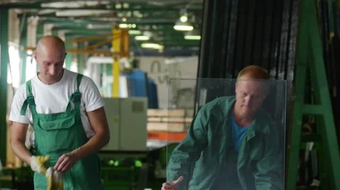 Two Workers in Green Uniform, Put The Sheet of Glass Down, Man in Civilian Has Video stock 53011433