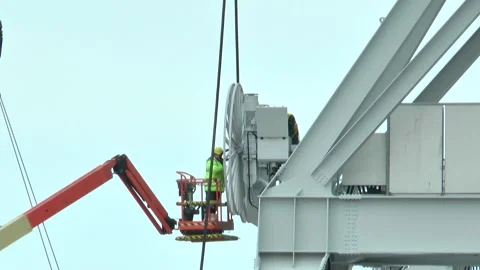 Two workers in green vests work on a crane Stock Footage 232215045
