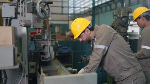 Two workers in hard hats operate heavy machinery Stock Footage 346268587