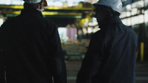 Two Workers Hard Hats Walking in Industrial Area with Cranes Stock Footage 58788939