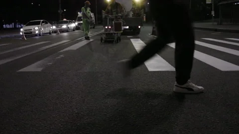 Two workers implement road markings on asphalt at night close up Stock Footage 221925677