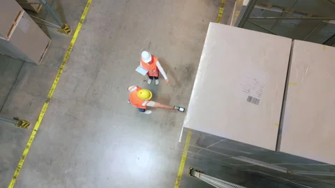 Two workers inspect packages in a warehouse. 動画素材 308002364