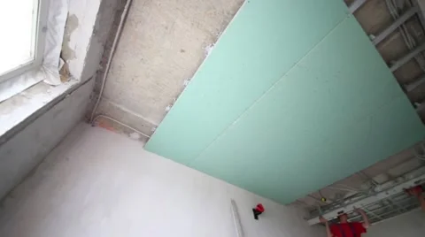 Two workers install framework for hung ceiling in new flat Stock Footage 45230439