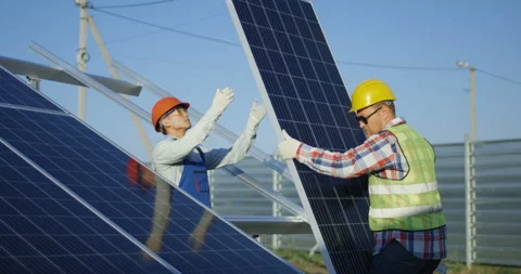 Two workers install a solar panel Stock Footage