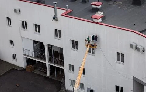Two workers installing an air conditioning Stock Photos