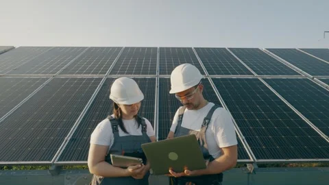 Two workers with a laptop discuss the installation and efficiency of solarpanels Stock Footage 272994162