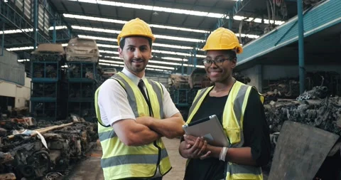 Two workers mechanic with safety suit helmet in old auto parts factory Stock Footage 156384285
