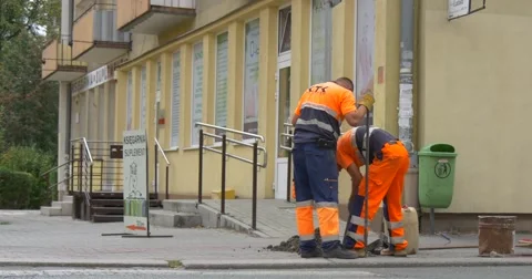 Two Workers Men in Orange Workwear Are Digging Installing the Handrails at Stock Footage 55303928