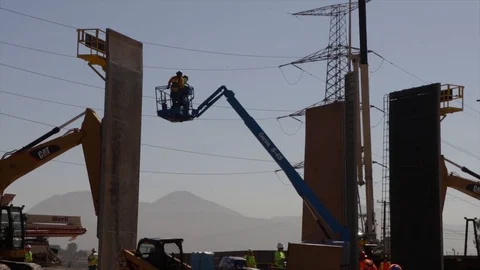 Two workers-men on a telehandler at the construction of The Trump's Wall Stock Footage 99043249
