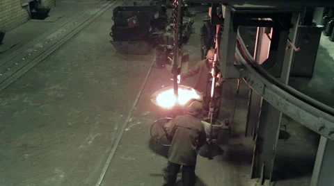 Two workers pour the liquid metal into container Stock Footage 62083767