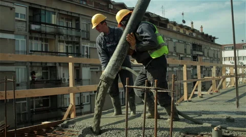 Two workers pulling large hose for concreting on construction site. Building. Video stock 47127696
