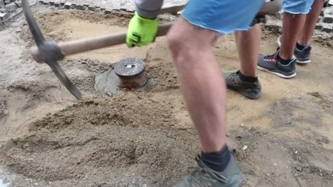Two workers repair the sidewalk, with a pickaxe and a shovel Stock Footage 159018809