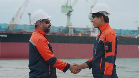 Two workers shake hands by a harbor Stock Footage 343333771