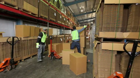 Two workers in shipping warehouse stacking boxes Stock Footage 61672058