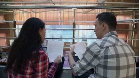 Two workers sit on floor and discuss contract inside Stock Footage 75655342