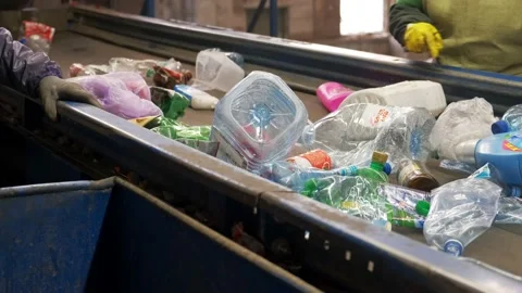 Two workers sorting plastic bottles in a recycling factory. Environmental Stock Footage 151068716