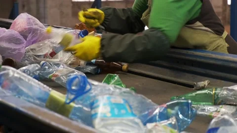 Two workers sorting plastic bottles in a recycling factory. Environmental Stock Footage 151068831