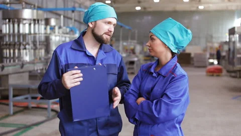 Two workers talking on the background of the plant Stock Footage 95903115