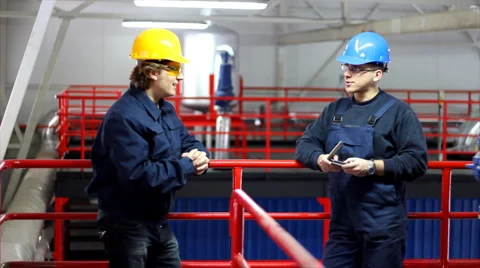 Two workers talking in a factory Stock Footage 996992