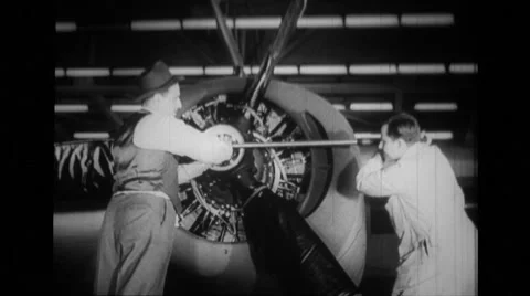 Two workers tightens nut of propeller to aeroplane engine Stock Footage 39914517