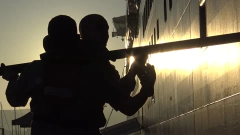 Two workers unload material from a cruise ship Stock Footage 311563187