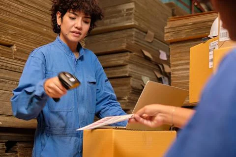 Two workers use a bar code scanner to check orders stock at parcels warehouse Stock Photos