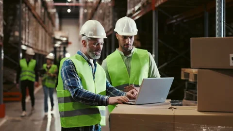 Two Workers Using Laptop in Logistic Centre, to Checking the Orders Before Stock Footage 245959962