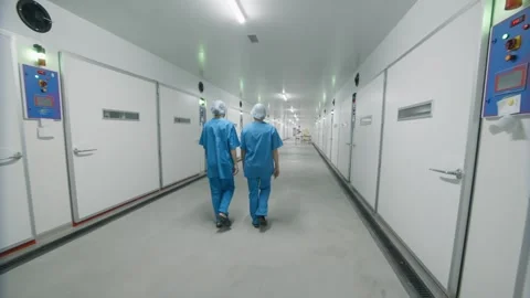 Two workers walking down a production hallway Stock Footage 295599456