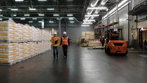 Two workers of warehouse team discussing while walking in warehouse. Aerial, top Stock Footage