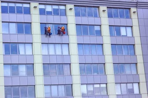 Two workers washing a skyscraper windows Foto stock