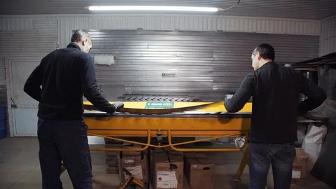 Two workers working for the machine, which bends the sheets of metal Stock Footage 108648676