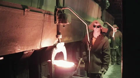Two workers works with liquid iron in the ironworks plant Stock Footage 62083280