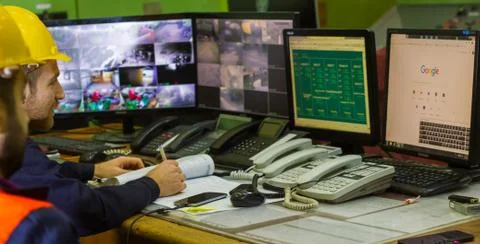 The two workers in yellow helmets in control panel in the laboratory Stock Photos