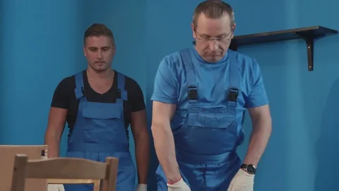 Two workmen carry boxes in the kitchen. Stock Footage 116537311