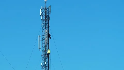 Two workmen on a cell tower. Maintenance staff at the work. High-altitude works Stock Footage 311453565