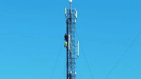 Two workmen on a cell tower. Maintenance staff at the work. High-altitude works Stock Footage 315439263
