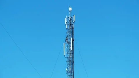 Two workmen on cell tower. Repairmen install new cable and equipment Stock Footage 317853355